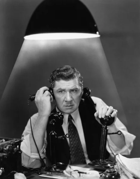 Man using two telephones — Stock Photo, Image