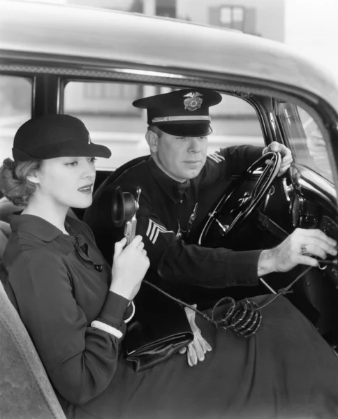 Γυναίκα που χρησιμοποιεί το ραδιόφωνο στο αυτοκίνητο με αστυνομικό — Φωτογραφία Αρχείου