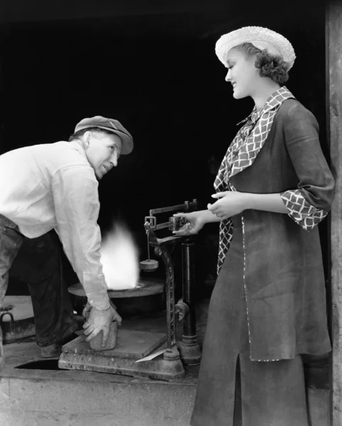 Frau mit Mann in Gießerei wägt Silber — Stockfoto