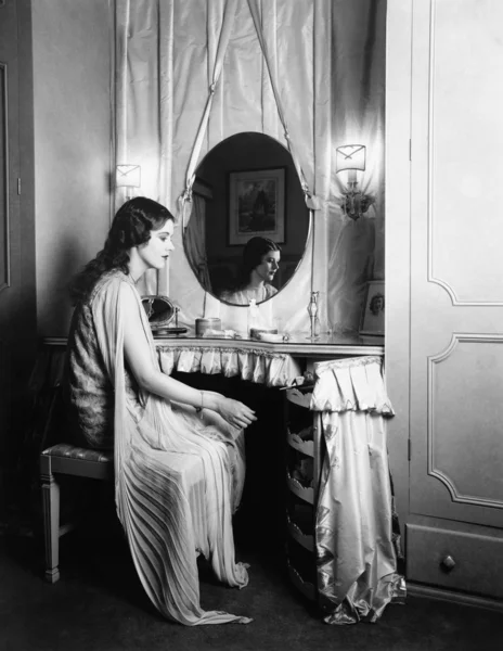 Kobieta siedzi na toaletkę — Zdjęcie stockowe