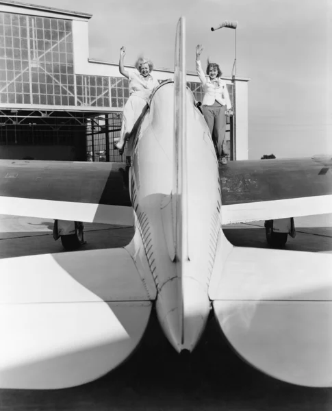 Dvě ženy, mává z křídla letadla — Stock fotografie
