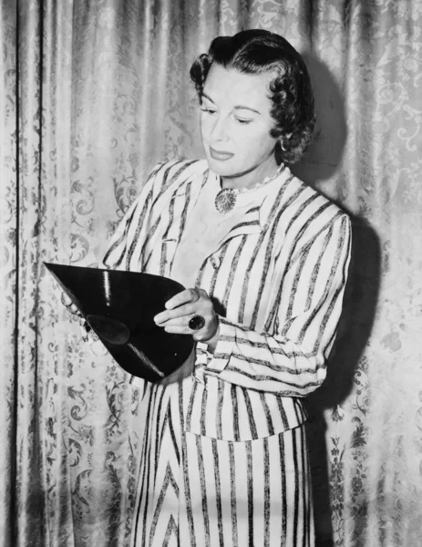 Rekor kırmaya çalışan, genç bir kadın kıvıran bir gramofon kaydı — Stok fotoğraf