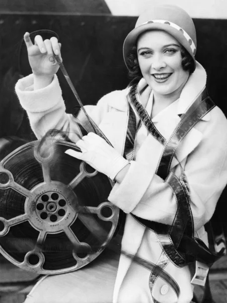 Ona etrafı sarılı film ile gülümseyen genç bir kadın — Stok fotoğraf