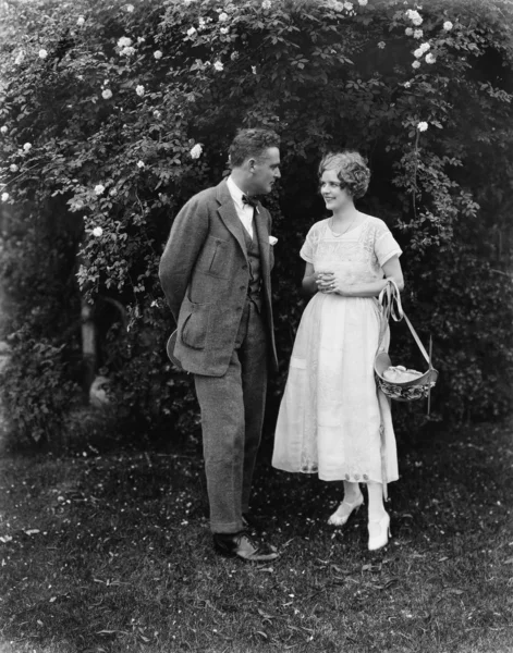 Paar die samen in een tuin staan en elkaar aankijken — Stockfoto