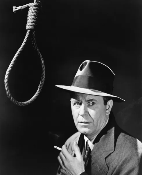 Man in hoed en sigaret die naast een strop — Stockfoto