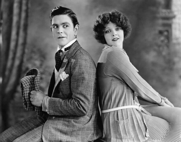 Couple sitting back to back and flirting