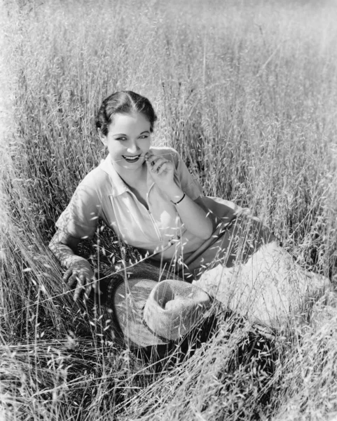 年轻女子坐在草地上 — 图库照片