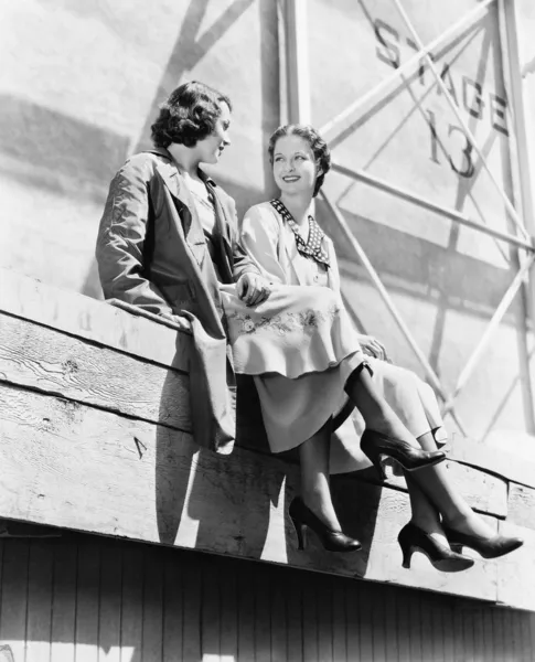 Zwei Frauen sitzen zusammen auf einem Gerüst — Stockfoto