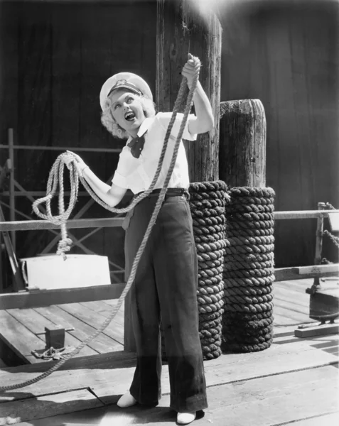 Ahoj z młodą kobietę w strój marynarski, trzymając ciężkie liny — Zdjęcie stockowe