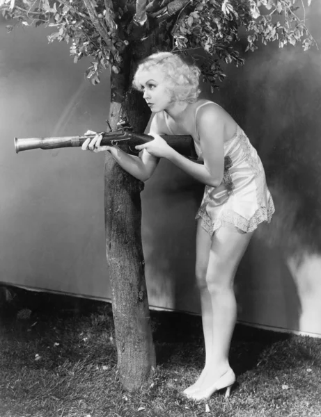 Jovem mulher em lingerie apontando um mosquete para seu suspeito — Fotografia de Stock