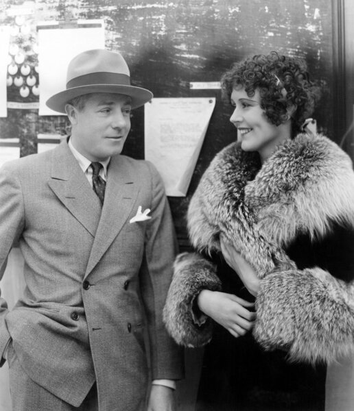 Женщина в шубе разговаривает с мужчиной
