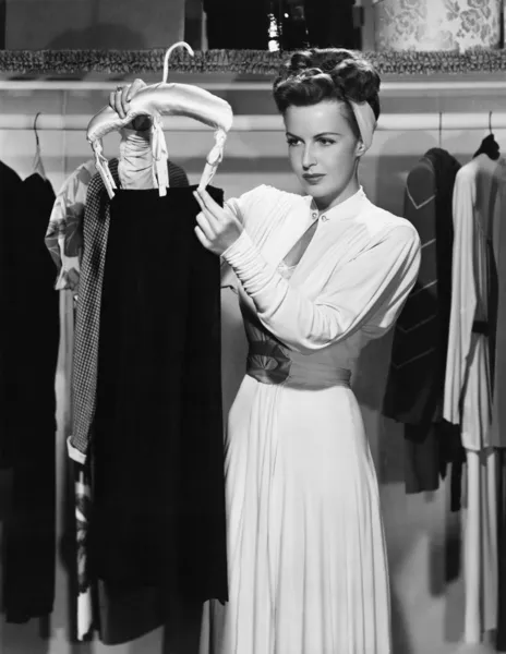 Mujer joven colgando una falda en el armario — Foto de Stock