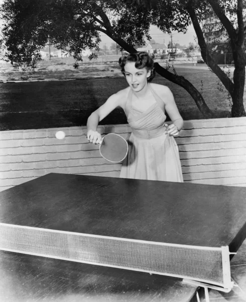 Молодая женщина играет в настольный теннис — стоковое фото
