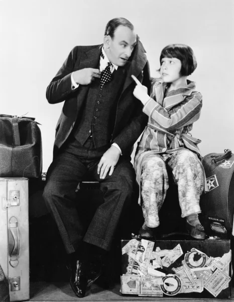 stock image Father and daughter sitting together on luggage