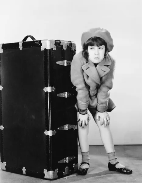 Menina de pé ao lado da mala — Fotografia de Stock