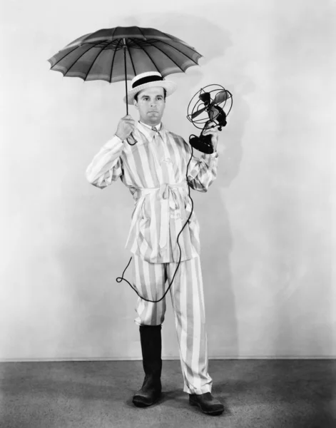 Ο άνθρωπος καιρικές συνθήκες με την ομπρέλα, εκκίνησης και ανεμιστήρα — Φωτογραφία Αρχείου