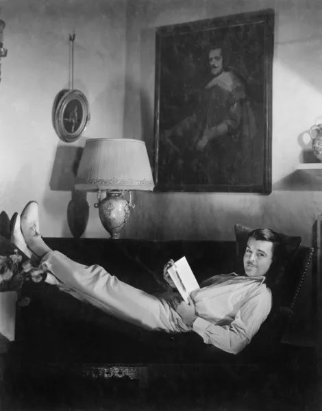 남자는 책을 읽고는 소파에 앉아 — 스톡 사진