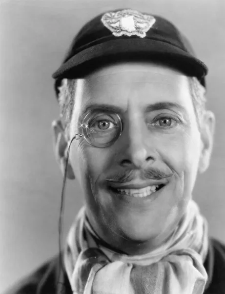 Un uomo che ride, un monocolo e un berretto in testa — Foto Stock