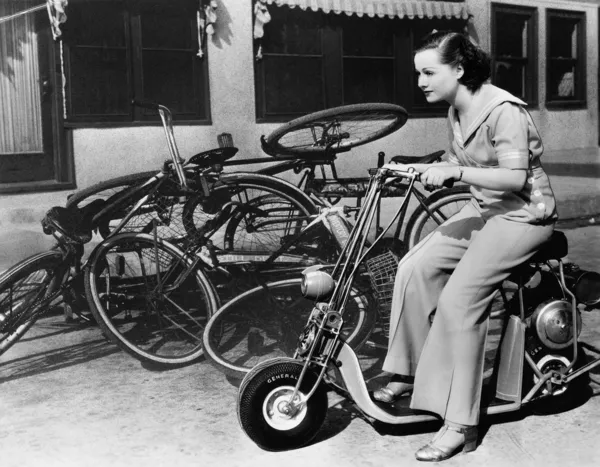 一个年轻女子在尘土中离开自行车，幻想微型摩托车 — 图库照片
