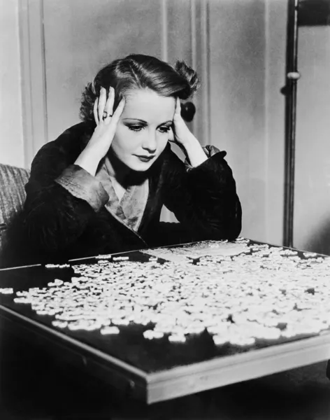 Jeune femme essayant de résoudre un puzzle — Photo