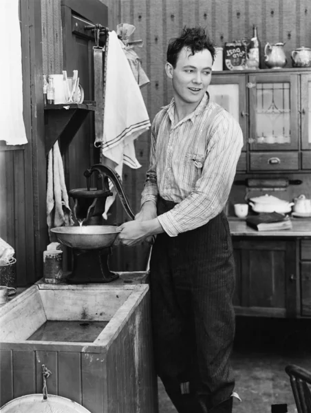 在厨房里，把水抽的男人 — 图库照片