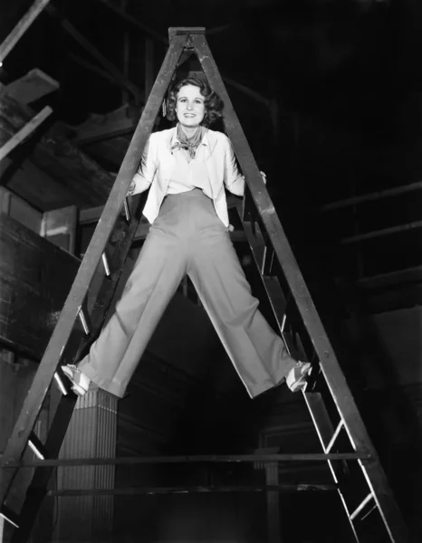 Mladá žena leze po žebříku nahoru — Stock fotografie