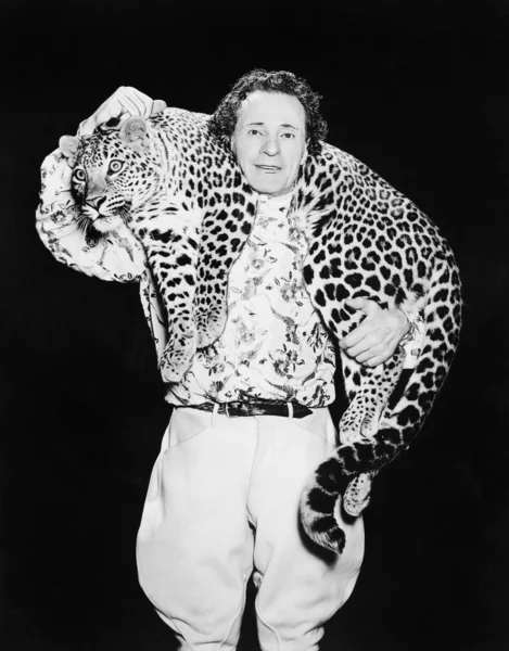 Чоловік позує з леопардом на шиї — стокове фото