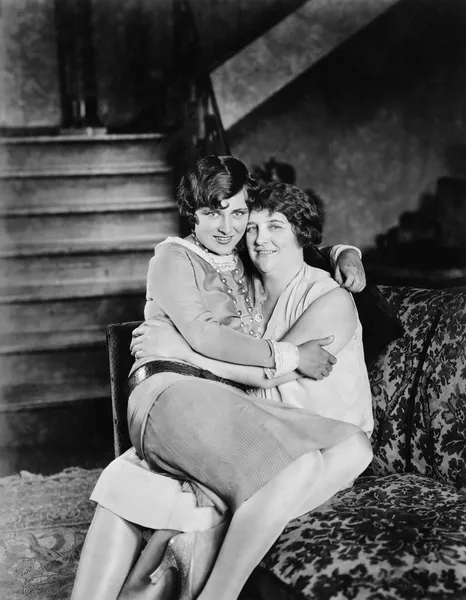 Birlikte diğerinin kucağına oturan iki kadın — Stok fotoğraf