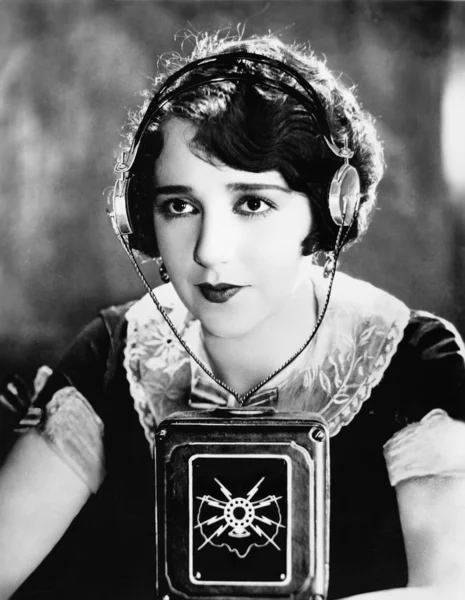 Mujer usando auriculares con un micrófono delante de ella —  Fotos de Stock