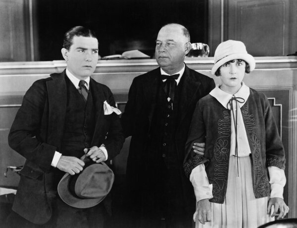 Three standing together while one is holding on to the other two