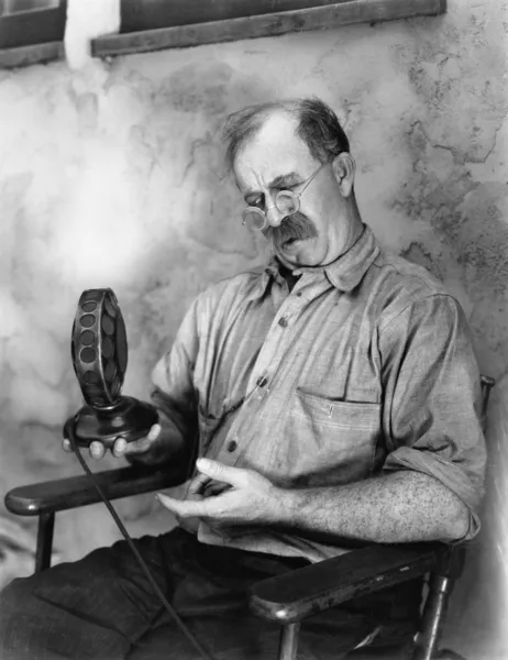 Άνθρωπος εξετάζοντας ένα μικρόφωνο — Φωτογραφία Αρχείου