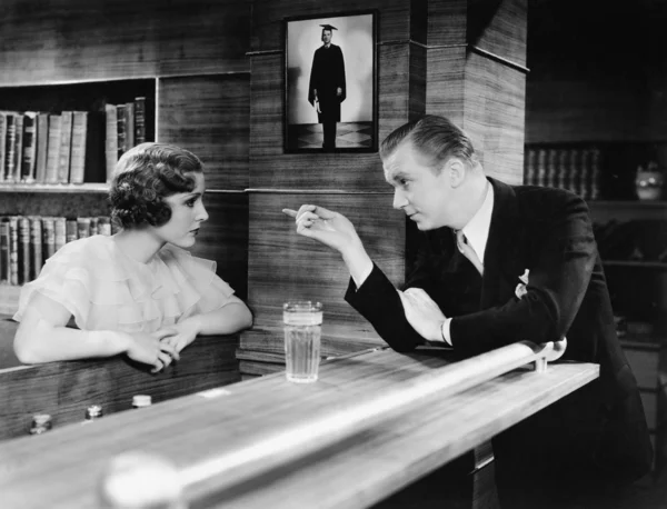 Man and woman standing together at a bar counter and talking — Stock Photo, Image