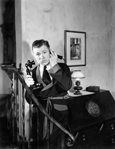 Homem em seu apartamento ouvindo em seu telefone — Fotografia de Stock