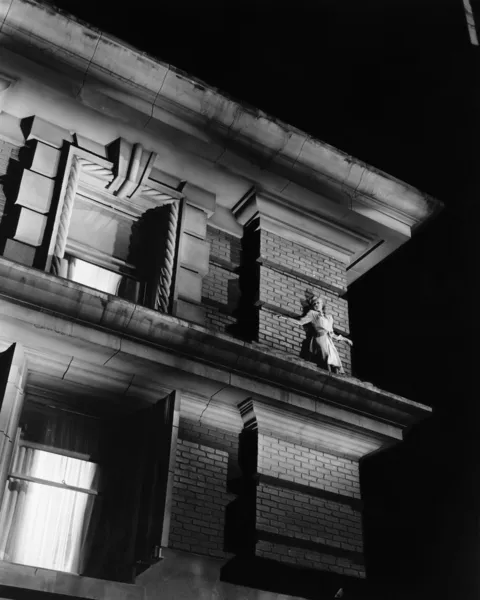 Kobieta stojąc na szczycie budynku na półce — Zdjęcie stockowe