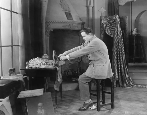Mann in seinem Atelier zieht Schuhe an — Stockfoto
