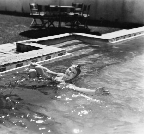 Woman swimming in a pool with a swimming cap