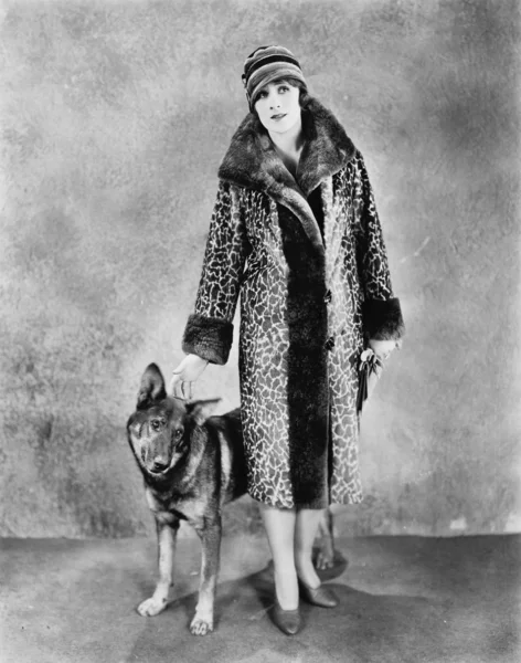 Femme dans son manteau de fourrure à motifs girafe et son chien — Photo