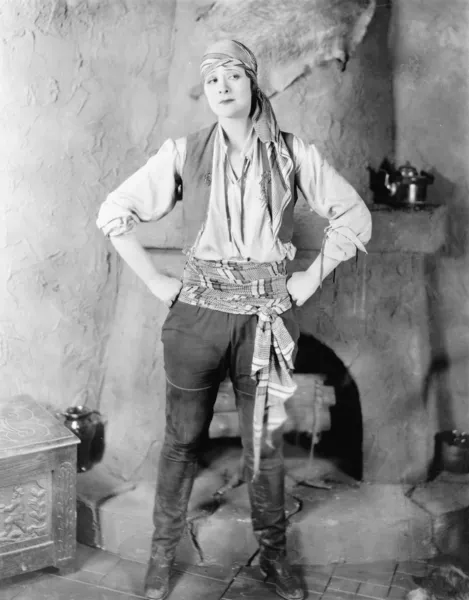 海賊の衣装で暖炉の前で立っている女性 — ストック写真