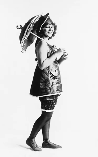 Kvinna poserar i en klänning med ett parasoll — Stockfoto