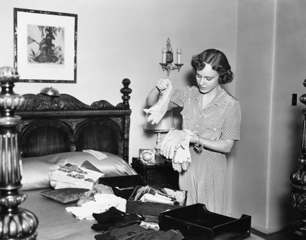 Žena v její ložnici třídění rukavice — Stock fotografie