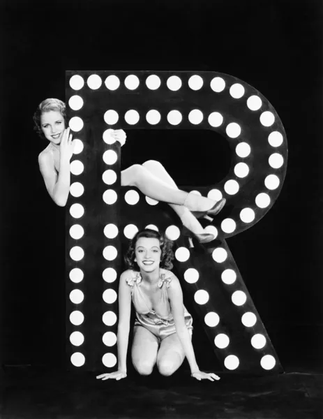 Zwei junge Frauen posieren mit dem Buchstaben r — Stockfoto