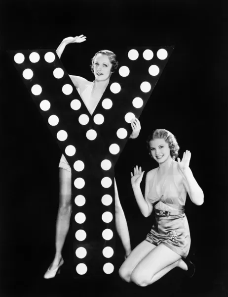 Två unga kvinnor poserar med bokstaven y — Stockfoto