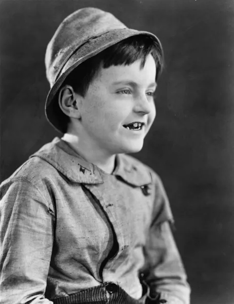 一个男孩在一顶帽子的肖像和咧着嘴笑 — 图库照片