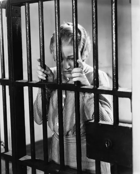 年轻的女子站在监狱牢房 — 图库照片