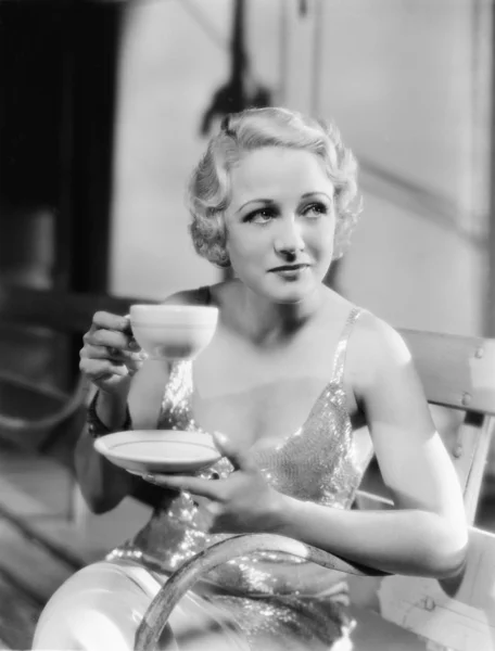 Νεαρή γυναίκα που κρατάει ένα φλιτζάνι τσάι — Φωτογραφία Αρχείου