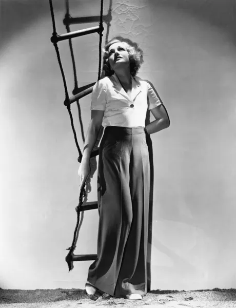Ip merdiven holding ve bakmak genç kadın — Stok fotoğraf