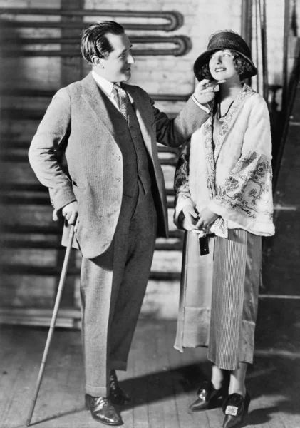 L'uomo e una giovane donna con un cappello che si guardano — Foto Stock