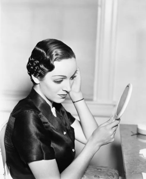 Profil mladá žena při pohledu do zrcadla, kontrola její vlasy — Stock fotografie