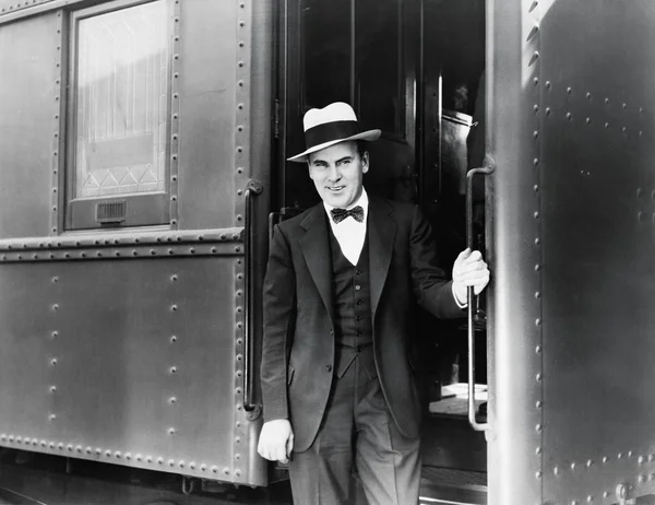 Молодой человек стоит у входа в поезд — стоковое фото