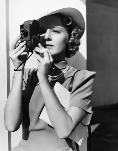 Retrato de una mujer joven tomando una foto con una cámara — Foto de Stock